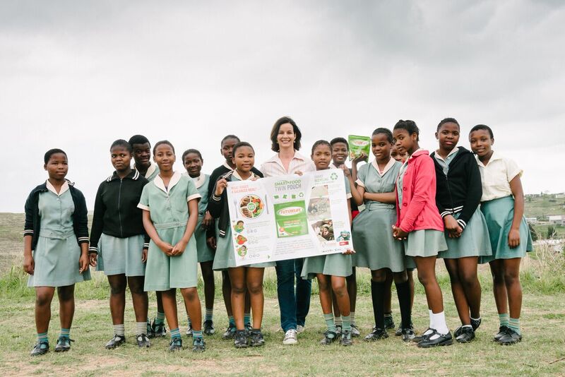 Julika Falconer, CEO of Futurelife Foundation Trust, proudly stands with learners from St Christophers Primary School in KwaDukuza, to celebrate the start of the food pouch delivery.